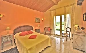a bedroom with a bed with red pillows on it at Gite Four De Mon Père in Salignac Eyvigues