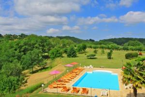 an overhead view of a swimming pool with chairs and umbrellas at Gite Four De Mon Père in Salignac Eyvigues