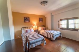 ein Schlafzimmer mit zwei Betten und einem Tisch und einem Fenster in der Unterkunft Ferienhaus für 4 Personen und 2 Kinder in Durcal, Andalusien Provinz Granada in Dúrcal