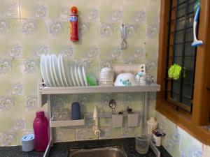 a kitchen sink with plates and dishes on a wall at AL MANAL K-002 Premium 2BHK Retreat in Bhatkal