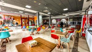 a restaurant with colorful chairs and tables in a restaurant at Hotel El Atalaya in Fuentidueña de Tajo