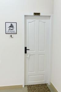 a white door in a white room with a rug at AL MANAL K-002 Premium 2BHK Retreat in Bhatkal
