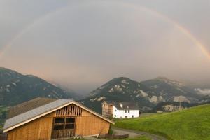 a rainbow over a mountain with a building and a house at Hof Quadra in Flerden