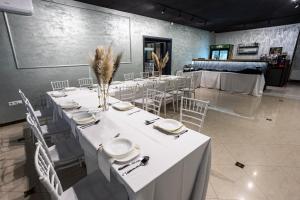 Habitación grande con mesas, sillas y manteles blancos. en Motel Calypso Travnik, en Travnik