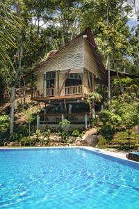 a house with a deck next to a swimming pool at Fundo Baños in Tarapoto +9 photos