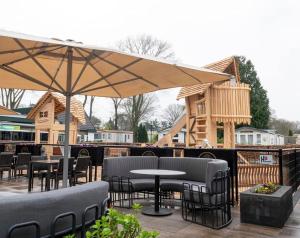 a patio with tables and chairs and an umbrella at 't Haasnestje in Harderwijk