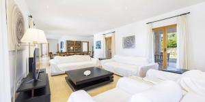 un soggiorno con mobili bianchi e una TV di Son Ropit a Calas de Mallorca Altre 24 foto