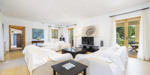 un soggiorno con mobili bianchi e una TV di Son Ropit a Calas de Mallorca