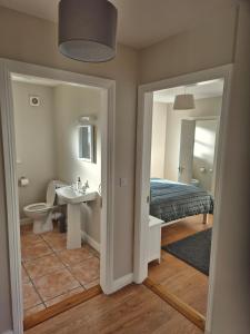 a bedroom with a bed and a sink and a mirror at Beautiful Spacious 4-Bedroom House in Louisburgh in Louisburgh