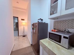 a kitchen with a microwave and a refrigerator at Blooming Residences by Gold Mark Property Consultants in Nugegoda +3 photos