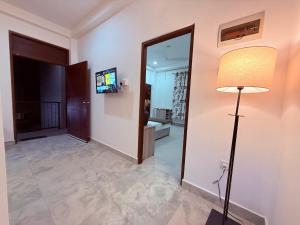 a hallway with a floor lamp and a mirror at Blooming Residences by Gold Mark Property Consultants in Nugegoda