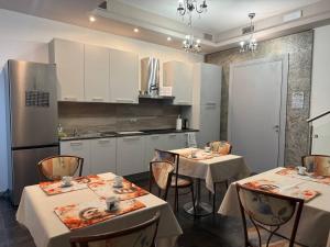 una cocina con 2 mesas y armarios blancos en Sweet Dreams Residence, en Brugine 16 fotos más