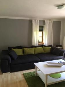 a living room with a black couch and a coffee table at Ferienwohnung Schoenk In Havetoft in Havetoft