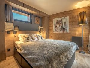 a bedroom with a wolf picture on the wall at Appartement rénové à Méribel, 3 chambres, accès skis, WIFI, parking - FR-1-688-99 in Mussillon