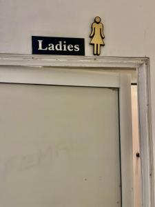 a sign above a door with a woman on it at Ishu beach hostel in Mirissa