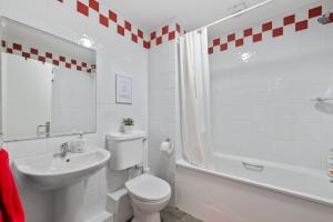 um banheiro branco com vaso sanitário e pia em 5 Rushbrooke Hotel Apartments Cobh County Cork em Cobh mais 17 fotografias