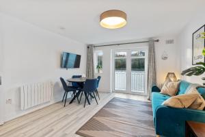 uma sala de estar com um sofá azul e uma mesa em 5 Rushbrooke Hotel Apartments Cobh County Cork em Cobh