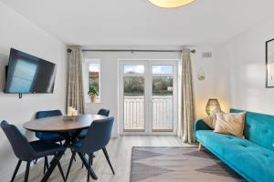 uma sala de estar com um sofá azul e uma mesa em 5 Rushbrooke Hotel Apartments Cobh County Cork em Cobh