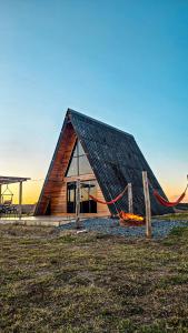 een blokhut met een hangmat ervoor bij Chalé Tia Barbara in Itutinga