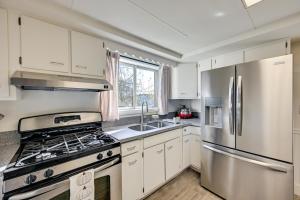 Una cocina con gabinetes blancos y electrodomésticos de acero inoxidable. en 3 Mi to Auburn Station! Commuter-Friendly Home, en Algona
