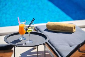 - une table avec deux verres de jus d'orange et une serviette dans l'établissement Villa Dolcea Elegant Und Stilvoll Mit Pool, à Kaštel
