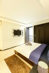 马拉喀什le duplex familial spacieux的一间卧室设有一张大床和一台墙上的电视。