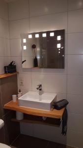 ein Badezimmer mit einem weißen Waschbecken und einem Spiegel in der Unterkunft Ferienwohnung Himmelreich in Antfeld