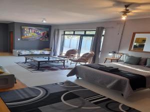 a bedroom with a bed and a living room at The Regiment Self Catering Accommodation in Welgemoed