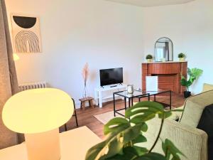 een woonkamer met een bank en een tv bij Le Sweet Escape - Vue Sur La Cathédrale in Beauvais +24 foto's