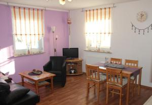 un salon avec un canapé, une table et des chaises dans l'établissement Fewo Erzgebirge, à Dorfchemnitz