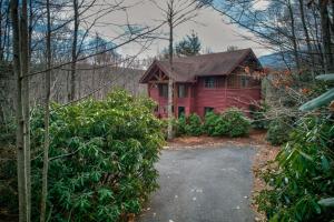 a red house with a driveway in front of it at Muir Lodge in Blowing Rock