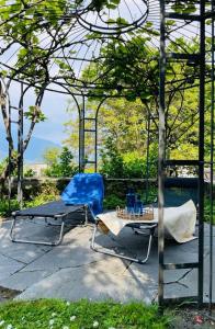 2 Stühle und ein Tisch unter einer Pergola in der Unterkunft Rustico-Ferienwohnung mit Garten Casa-Ritz in Vairano