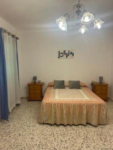 a bedroom with a bed and a chandelier at Casa grande en Garachico centro in Garachico +43 photos
