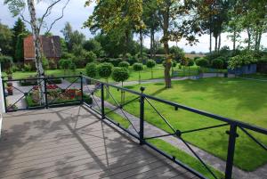 eine Holzterrasse mit einem Zaun in einem Park in der Unterkunft Ferienwohnung für 3 Personen ca 70 m in Swantow, Ostseeküste Deutschland Rügen in Poseritz