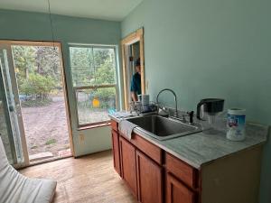 une cuisine avec un évier et une personne regardant par la porte dans l'établissement Chi Camps, à Pagosa Springs