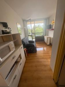 a kitchen with a microwave and a living room at Studio accueillant avec vue montagne à Font-Romeu in Font-Romeu