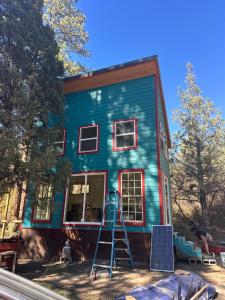 une maison bleue avec une échelle devant elle dans l'établissement Chi Camps, à Pagosa Springs