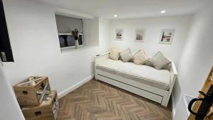 Una habitación blanca con una cama con almohadas. en Cwm Uchaf Holiday Home, hot tub and horse view!, en Abergele