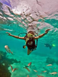 a woman swimming in the water with a diver at Casa Paraiso Beira-Mar in Maracajaú