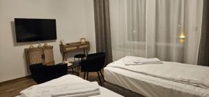 穆希纳ZŁOCKIE HILL spa的有两张床和一台电视的酒店房间