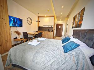 a bedroom with a large bed with blue pillows at Harmony, Residence Hill A85 in Kopaonik +65 photos