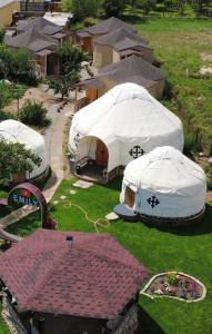 a group of tents in a yard with houses at Guest House Emily in Bokonbayevo