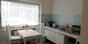 une cuisine avec une table, des chaises et un évier dans l'établissement Appartement In Ruhbank Mit Garten Und Terrasse, à Pirmasens