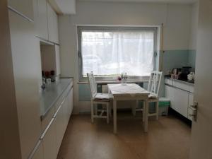 une cuisine avec une table et des chaises et une fenêtre dans l'établissement Appartement In Ruhbank Mit Garten Und Terrasse, à Pirmasens