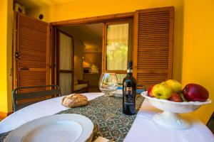 - une table avec une bouteille de vin et un bol de fruits dans l'établissement Trilocale Cielo, à Alberese