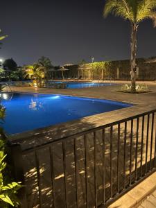 a swimming pool at night with a fence at Balcony studio in Sheikh Zayed