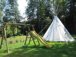 un parque infantil con un tobogán y un tipi en Farbhaus Bleiche, en Rohrbach