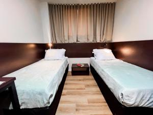 two beds in a room with a window at Smart mundurucus 1427 in Belém