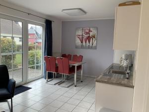 ein Esszimmer mit einem Tisch und roten Stühlen in der Unterkunft Appartement in Middelhagen mit Terrasse und Garten in Middelhagen + 3 Fotos