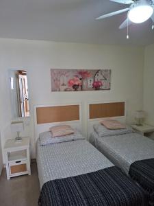 a bedroom with two beds and a ceiling fan at Los Hibiscos 406 in Costa Calma +32 photos